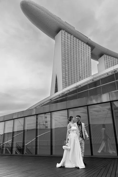 Gelin ve damat, Singapur şehrinin arka planına karşı. Güneşin doğuşu düğün fotoğrafı. - Evet. Yüksek kalite fotoğraf