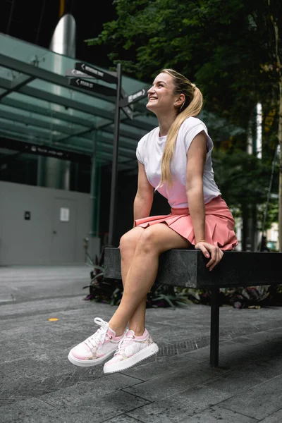 Singapur, 14 Şubat 2023: Pembe etekli, beyaz tişörtlü, uzun sarı saçlı çekici bir kız Singapur, Çin Mahallesi 'nin turistik bölgesinde yürüyor. Yüksek kalite fotoğraf