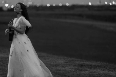 Gelinlik giymiş beyaz bir gelin Ukulele çalar dört telli Hawaii gitarı. Yüksek kalite fotoğraf