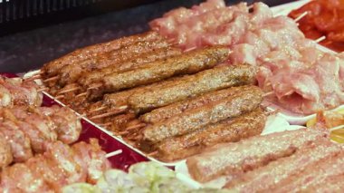 Yarı pişmiş et ürünleri. Ev ızgarasında pişirmek için soslu et hazırlıkları. Avrupa 'da mağaza tezgahı. Kebap, tavuk ve şiş için biftek. Parçalara ayrılmış et. Yüksek kalite 4k görüntü