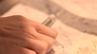 Hamur köfteleri için küçük bir oklavayla hamuru saran elleri kapat..