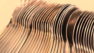 Parlak temiz yüzeyleri ve düzenli mutfak atmosferini gösteren cilalı çatal ve kaşıklar günlük yemek için temiz ve taze bir şekilde sergilenen parlayan metal sofra takımlarıyla yıkandıktan sonra toplandı. Yüksek kalite 4k görüntü