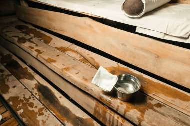 Sauna içi sıcak sobaya su dökmek için ahşap kepçeyle kaplı.