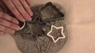 Potter kurabiye kesicilerle kil Noel süsleri yapıyor.