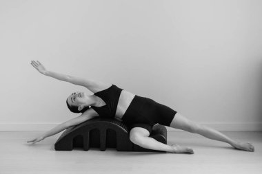 Stüdyo eğitiminde kullanılan pilates ekipmanının siyah beyaz fotoğrafı.