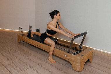 Model ile reformist eğitim makinesinde yetişkin pilates oturumu