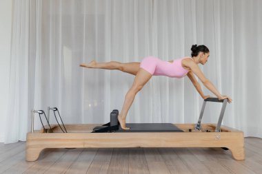 Kompleks egzersizler yapan modelli pilates reformist eğitim makinesi