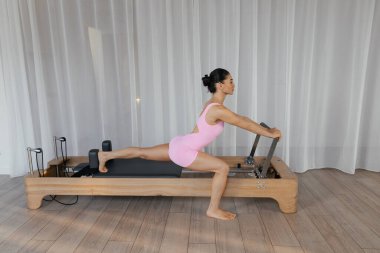 Kompleks egzersizler yapan modelli pilates reformist eğitim makinesi