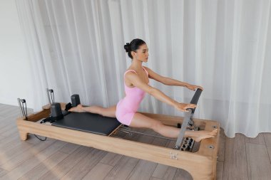 Kompleks egzersizler yapan modelli pilates reformist eğitim makinesi