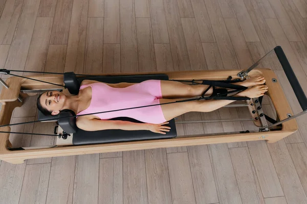 Model egzersizleriyle birlikte stüdyodaki Pilates yenilikçi eğitim makinesinin genel görünümü