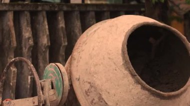 Yavaş çekimde çalışan bir beton karıştırıcıya bir kova kuru çimento dökülüyor. Beton harç malzemeleri karıştırılıyor, yakın plan. Yüksek kalite 4k görüntü