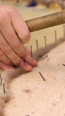 Kürkçü kürkleri ahşap çekiçle tezgahın üzerine koyuyor. Yüksek kalite 4k görüntü