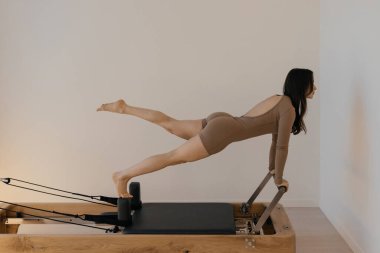 Pilates Reformist eğitim makinesi modelle birlikte çalışıyor