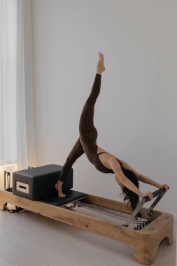 Stüdyoda model tarafından kullanılan pilates kutusu olan Pilates Reformcusu