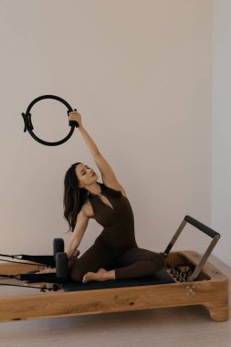 Stüdyo oturumunda model tarafından kullanılan pilates yüzüklü pilates reformatörü.