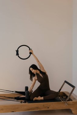 Stüdyo oturumunda model tarafından kullanılan pilates yüzüklü pilates reformatörü.