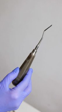 Elinde paslanmaz çelik bir alet var.