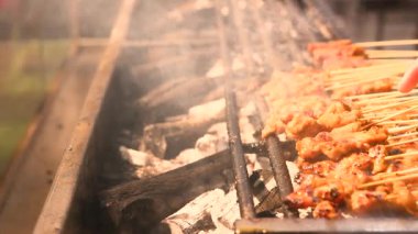 Karamelize edilmiş yüzey, dumanlı aroma, el yapımı terbiye ve dinamik açık hava mutfağı deneyimini vurgulayan şiş etin sıcak közleri üzerinde ayrıntılı bir perspektif.