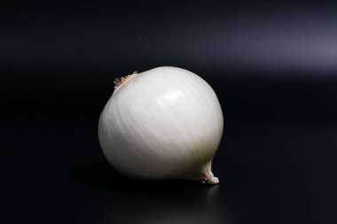 Koyu arkaplanda soyulmuş beyaz soğan kafası. Yakın çekim..