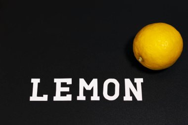 Ekranın sağ üst tarafında taze sarı limon var. Alttaki yazıt. Koyu arkaplan.