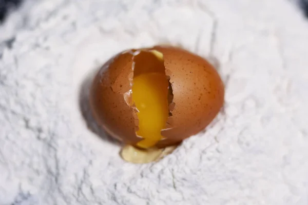 Ovo de frango quebrado em uma pilha de farinha branca. — Fotografia de Stock