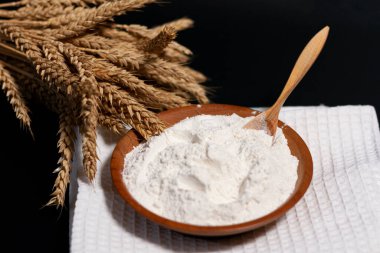 Beyaz unlu bir fincan. Tahta kaşık. Bir demet buğday filizi.. 