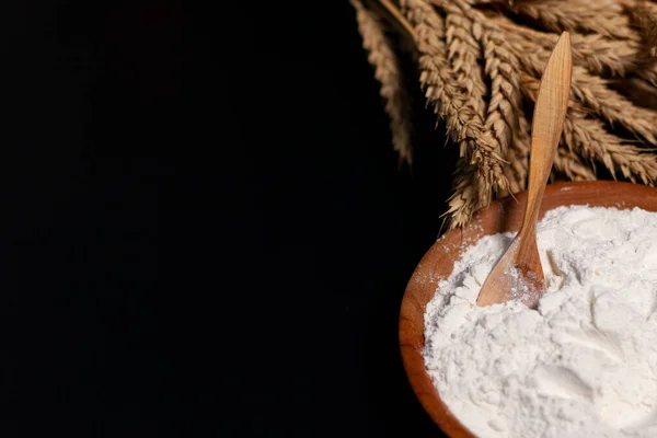 Tazza con farina bianca. Cucchiaio di legno. Un mazzo di spighe di grano. — Foto Stock