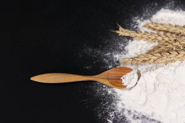 Ekranın sağ tarafında, bir demet buğday dikenleri ve bir tahta kaşık beyaz un yığını üzerine yerleştirilir..