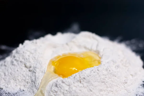 Broken chicken egg on a stack of white flour. — Stock Photo, Image