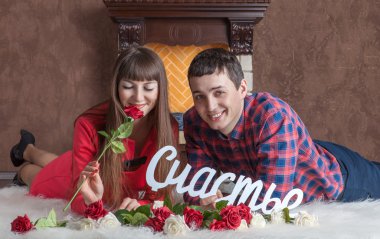 Aşık genç çift halı üzerinde şömine yakın yatıyor