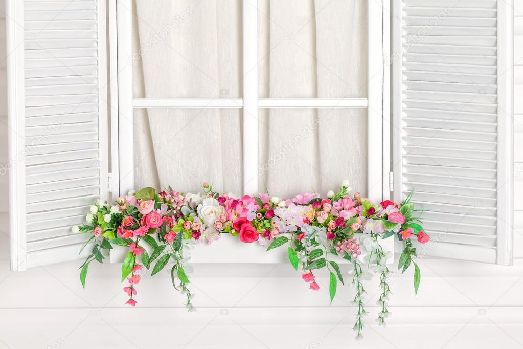 Blooming flower bed under the window.  Windowsill with flowers