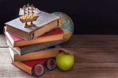 Eski okul kitapları, ders kitapları ve okul malzemeleri yalan ahşap bir masa üzerine. Küre içinde belgili tanımlık geçmiş.