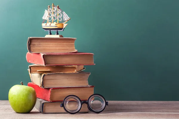 Los libros de la vieja escuela, los libros de texto y los útiles escolares yacen sobre una mesa de madera . —  Fotos de Stock