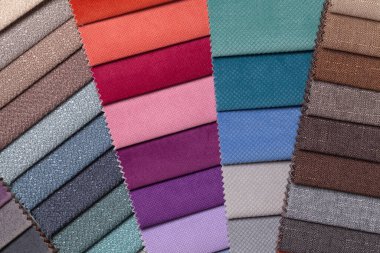 Farklı renklerde, arka planda dokuma örnekleri. Mobilyalar için iç kumaşın katalog ve palet tonu, yakın çekim. Hasır desenli çok renkli kumaş koleksiyonu.