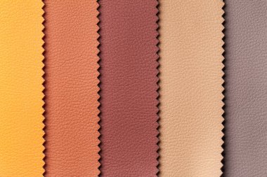 Deri tekstil örneği kahverengi ve kırmızı renkler, arka plan. Mobilyalar için iç kumaşın katalog ve kumaş tonu, yakın çekim. Deri desenli çok renkli kumaş koleksiyonu, makro.