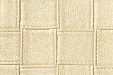 Açık altın ve krem rengi deri arka plan kare desenli ve dikişli, makro. Modern dekoratif hafif tekstil geometrik şekilli soyut bej arkaplan.