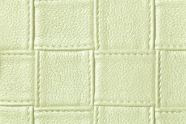 Açık yeşil deri arka plan dokusu kare desenli ve dikişli, makro. Modern dekoratif hafif zeytin tekstili geometrik şekilli soyut arkaplan.