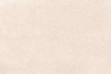 Süet kumaştan açık bej bir arka plan, yakın plan. Dikensiz krem tekstilin kadife dokusu, makro. Kahverengi keçeli tuval yapısı.