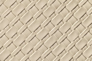 Açık bej ve hasır desenli kum rengi deri arka plan, makro. Çapraz çizgileri olan modern dekoratif tekstil krem arkaplanı.
