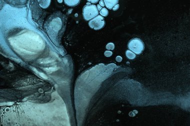 Soyut akışkan sanat arka planı siyah ve mavi parıltılı renkler. Turkuaz eğimli ve sıçramalı akrilik bir tablo. Dalgalı desenli suluboya arkaplan.