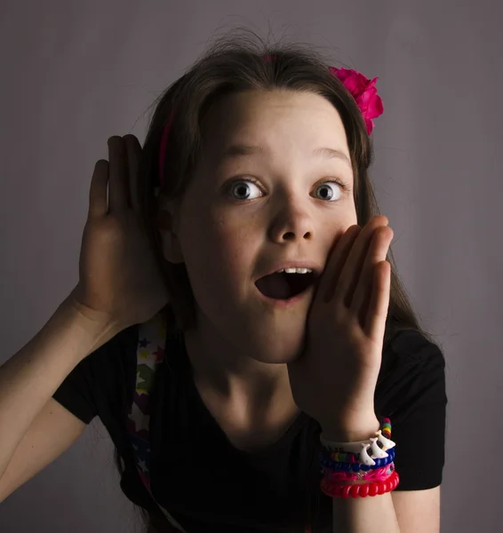 Hermosa chica emocional sobre un fondo gris — Foto de Stock