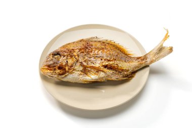 Grilled whole sea bream served on a plate on white background