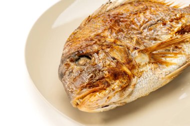 Grilled whole sea bream served on a plate on white background