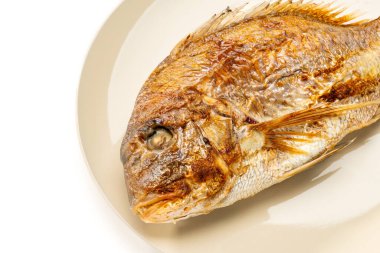 Grilled whole sea bream served on a plate on white background