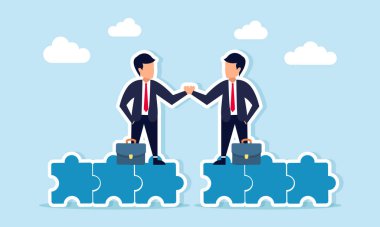 Yapboz parçasının üzerinde duran iki işadamı iş birliği anlaşmasını resmetmek için el sıkışıyor.