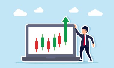 Yükselen yeşil şamdanla dizüstü bilgisayarın yanında duran işadamı, hisse senedi kar patlamasının ekran görüntülerini kırıyor