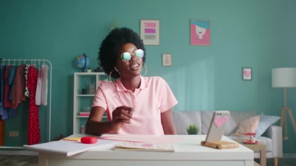 Mujer afroamericana estudia y habla por teléfono móvil — Vídeos de Stock