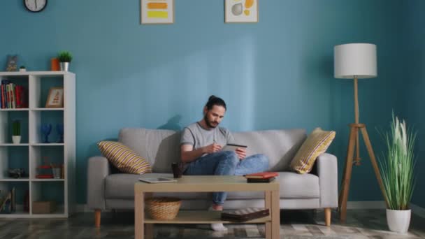 Muž kreslí v útulném obývacím pokoji — Stock video