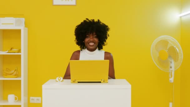 행복 한 흑인 여성, 노란색 방에서 노트북을 사용하고 있다 — 비디오