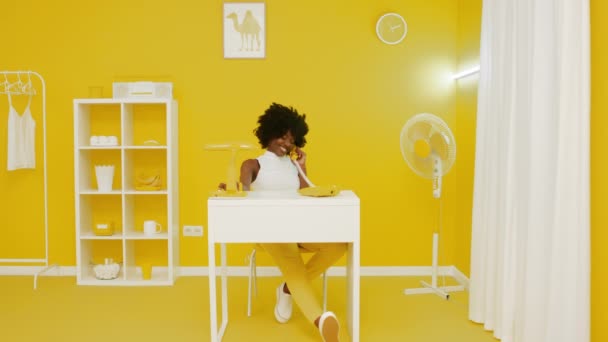 Черная женщина разговаривает по телефону в креативном офисе — стоковое видео